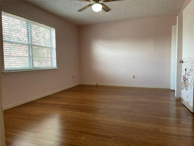 unfurnished room with dark hardwood / wood-style floors, ceiling fan, and a textured ceiling