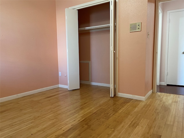 unfurnished bedroom featuring light wood-type flooring and a closet