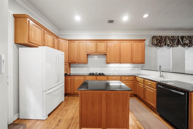 kitchen with sink, dishwasher, white refrigerator, light hardwood / wood-style floors, and a kitchen island