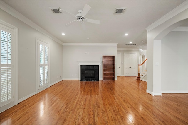 unfurnished living room with ceiling fan, crown molding, and a tile fireplace