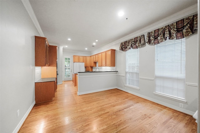 kitchen featuring sink, white fridge, crown molding, and light hardwood / wood-style floors