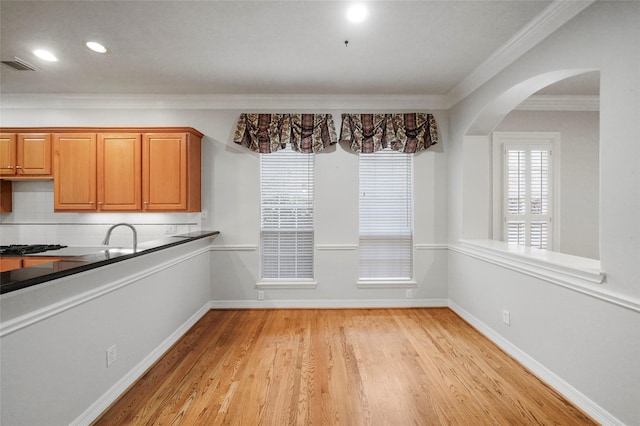 unfurnished dining area featuring light hardwood / wood-style floors and ornamental molding