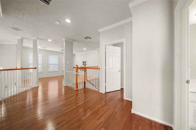 empty room with hardwood / wood-style flooring and ornamental molding