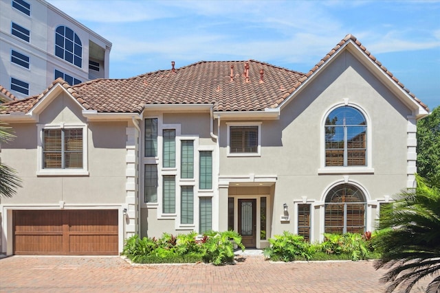 mediterranean / spanish home featuring a garage