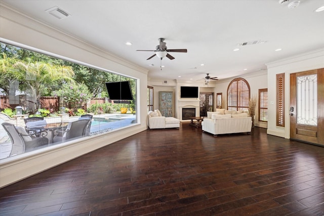 unfurnished living room with ceiling fan, crown molding, and dark wood-type flooring