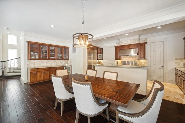 dining space with a chandelier, dark hardwood / wood-style flooring, and crown molding