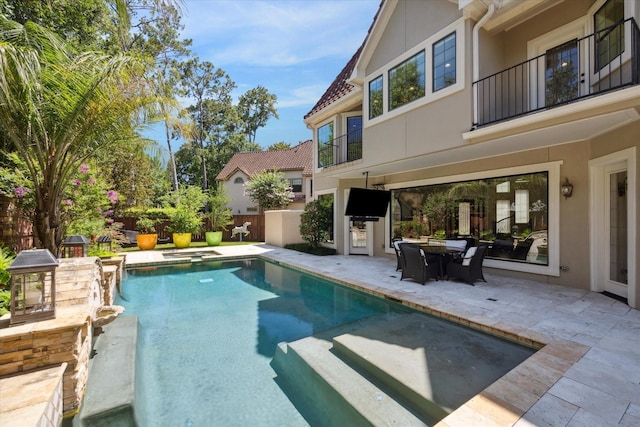 view of swimming pool featuring a patio area and exterior kitchen