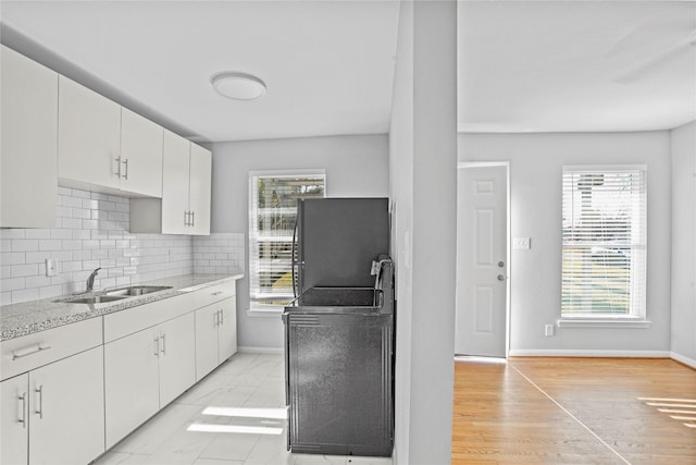 kitchen with white cabinets, decorative backsplash, plenty of natural light, and sink