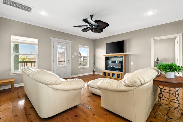 living room featuring ceiling fan, crown molding, and wood-type flooring