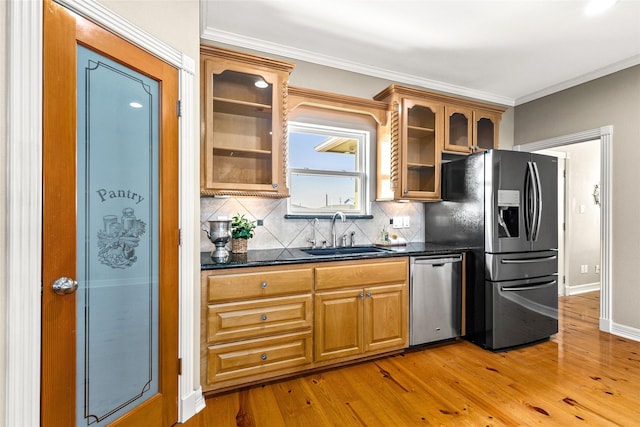 kitchen with light hardwood / wood-style floors, crown molding, sink, and stainless steel appliances