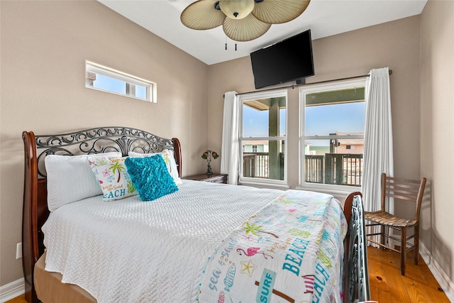 bedroom featuring multiple windows, hardwood / wood-style floors, and ceiling fan