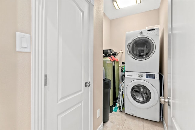 washroom featuring light tile patterned floors and stacked washer and dryer