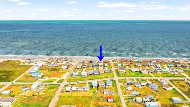 birds eye view of property with a water view and a beach view