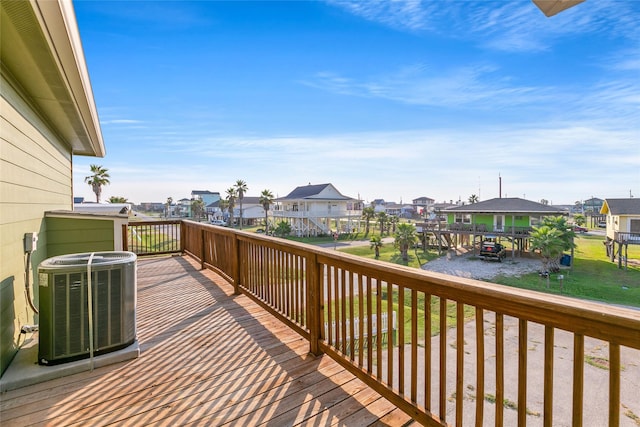 wooden deck with a water view and cooling unit