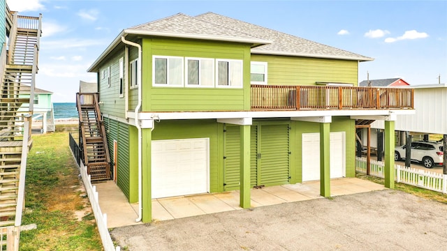 rear view of house featuring a water view and a garage