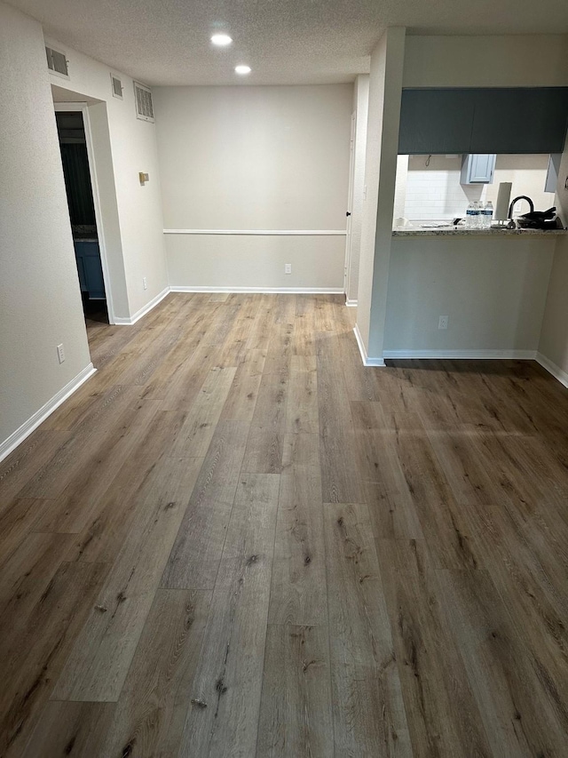 empty room featuring a textured ceiling and hardwood / wood-style flooring