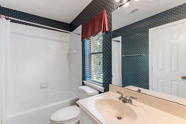 full bathroom featuring vanity, a textured ceiling, toilet, and shower / bath combo with shower curtain