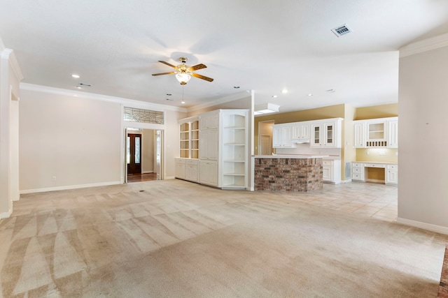 unfurnished living room featuring crown molding, ceiling fan, and light carpet