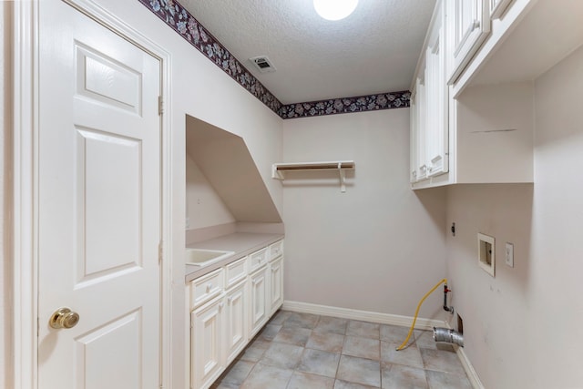 laundry area featuring washer hookup, cabinets, a textured ceiling, and hookup for an electric dryer