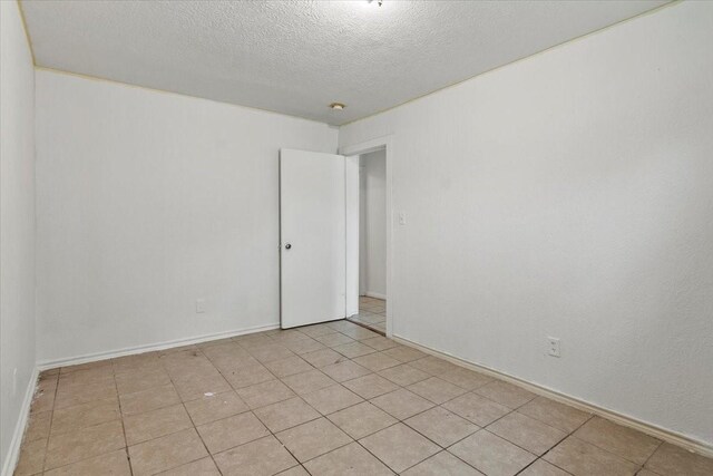 unfurnished room with a textured ceiling