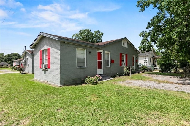 view of front of property featuring entry steps, brick siding, cooling unit, and a front lawn