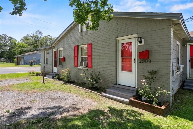 view of front of home with entry steps, cooling unit, and brick siding