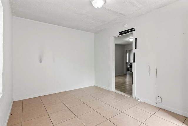 spare room featuring light hardwood / wood-style flooring and a textured ceiling