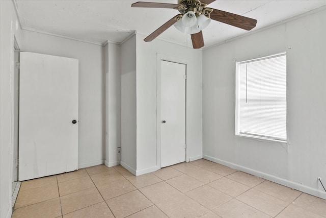 unfurnished bedroom with ornamental molding, ceiling fan, and light tile floors