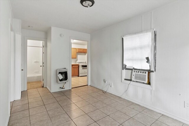 empty room featuring heating unit, light tile patterned floors, and cooling unit