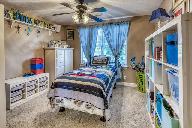 bedroom with a textured ceiling, carpet floors, and ceiling fan