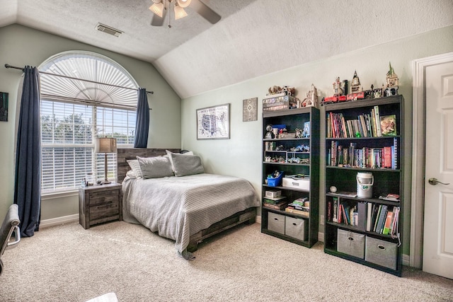 carpeted bedroom featuring ceiling fan, a textured ceiling, and vaulted ceiling