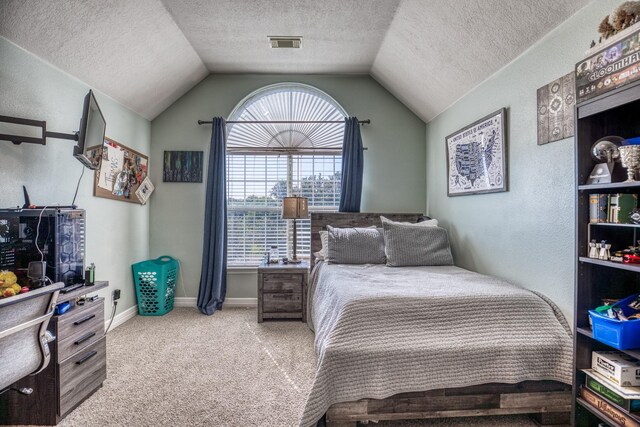 bedroom with a textured ceiling, lofted ceiling, and carpet flooring