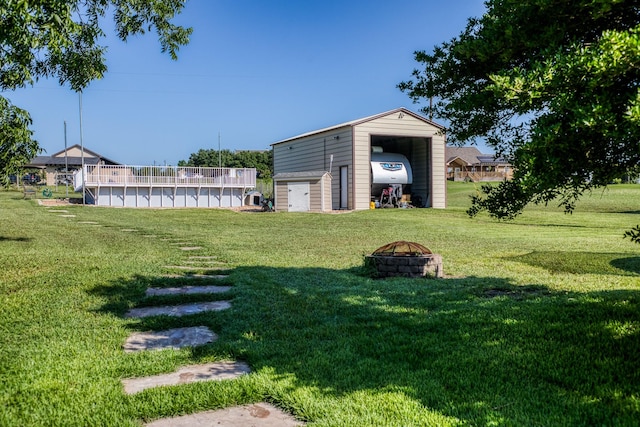 view of yard with an outdoor fire pit and a pool