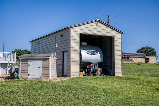 view of outdoor structure featuring a garage and a lawn