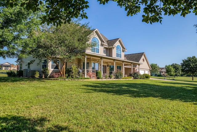 view of front of property with covered porch, a front yard, and a garage