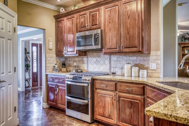 kitchen featuring crown molding, light stone countertops, decorative backsplash, sink, and stainless steel appliances