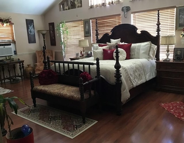 bedroom with lofted ceiling, multiple windows, and wood finished floors