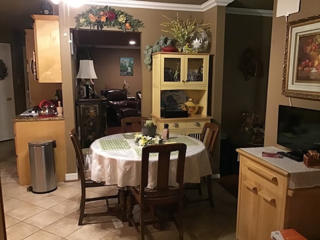 dining area with light tile patterned floors and ornamental molding