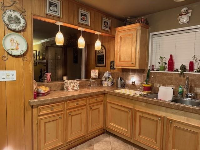 interior space with light tile patterned floors, a peninsula, pendant lighting, and decorative backsplash