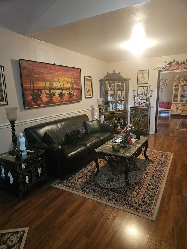 living area with vaulted ceiling and wood finished floors