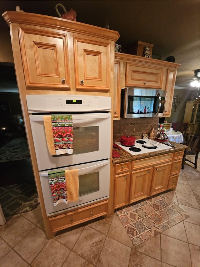 kitchen with white appliances, tasteful backsplash, and light tile patterned flooring