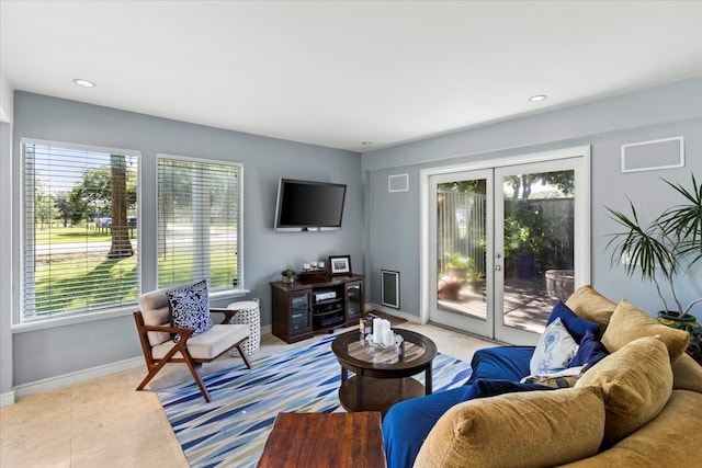 living room with french doors, plenty of natural light, and light tile patterned flooring