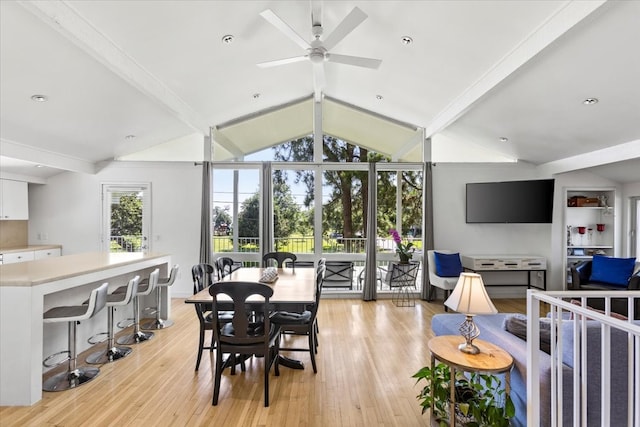 dining area with lofted ceiling with beams, light hardwood / wood-style floors, and ceiling fan