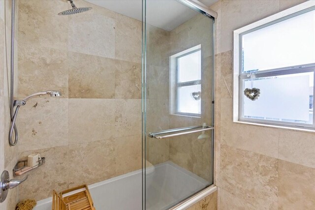 bathroom featuring shower / bath combination with glass door