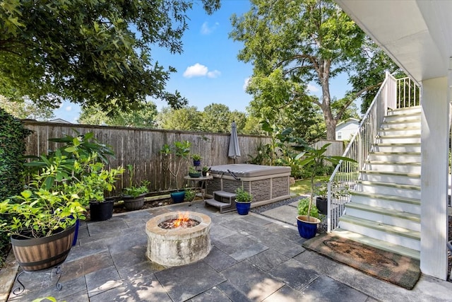 view of patio / terrace with an outdoor fire pit and a hot tub