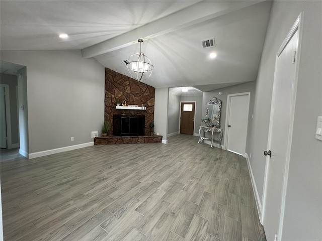 unfurnished living room featuring a fireplace, light hardwood / wood-style flooring, an inviting chandelier, and lofted ceiling with beams