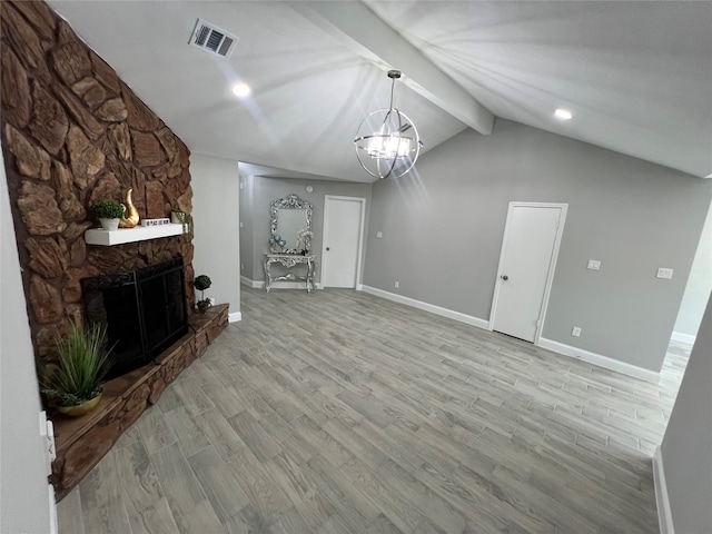 unfurnished living room with lofted ceiling with beams, an inviting chandelier, light hardwood / wood-style flooring, and a fireplace