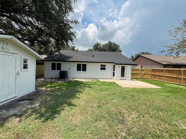 rear view of property with a shed, central AC, a patio area, and a lawn