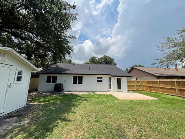 rear view of house featuring a lawn, central AC, and a patio