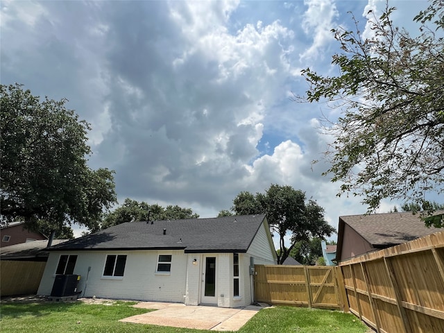 rear view of house featuring a patio area, a yard, and central AC unit